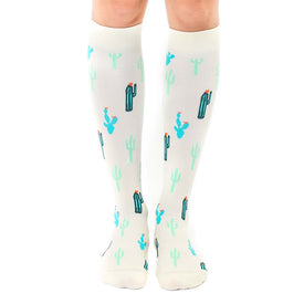 white knee-high women's socks with green cacti and pink flowers pattern.  