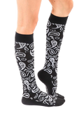 Lifestyle shot of a person wearing the black and silver paisley knee-high socks. [lf]