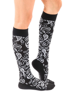 Lifestyle shot of a person wearing the black and silver paisley knee-high socks. [lf]