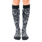 Pair of black knee-high socks with a silver paisley pattern.  The socks are shown from the front on a white background. [lf]
