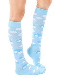 Lifestyle shot of a person's leg wearing a light blue knee-high sock with a white cloud print. The sock is slightly angled, showcasing the design. [lf]