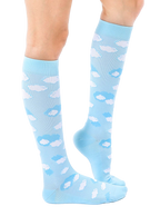 Lifestyle shot of a person's leg wearing a light blue knee-high sock with a white cloud print. The sock is slightly angled, showcasing the design. [lf]
