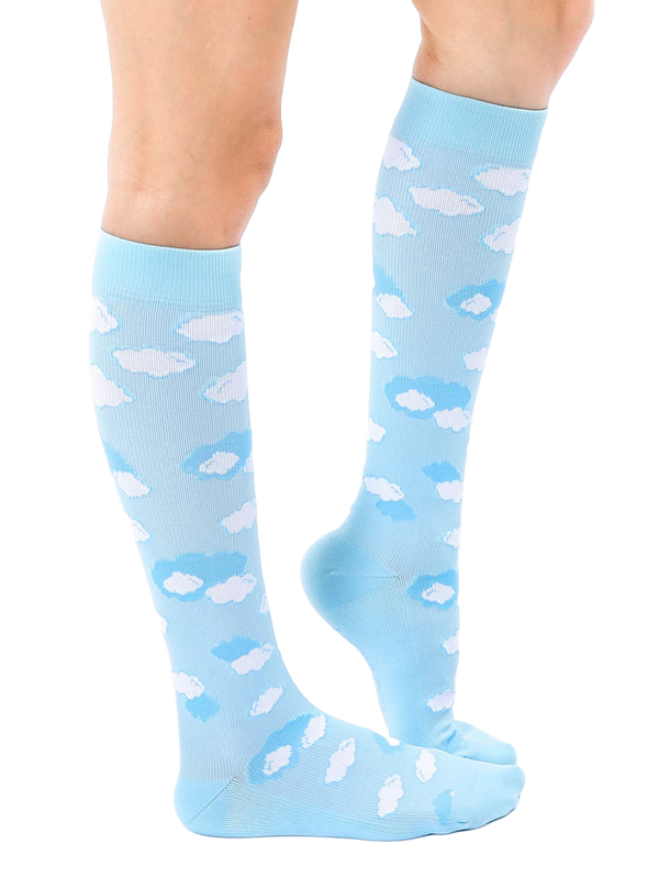 Lifestyle shot of a person's leg wearing a light blue knee-high sock with a white cloud print. The sock is slightly angled, showcasing the design. [lf]