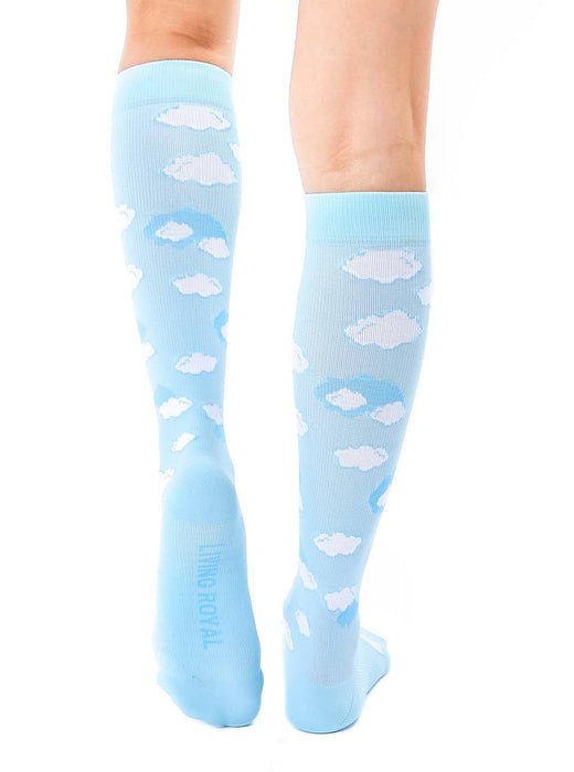 A pair of light blue knee-high socks with a pattern of white clouds.