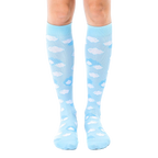 Pair of light blue knee-high socks with a scattered white cloud pattern. Shown on a model's legs against a white background. [lf]