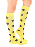 Lifestyle shot showing yellow smiley face knee-high socks on a model's legs. [lf]