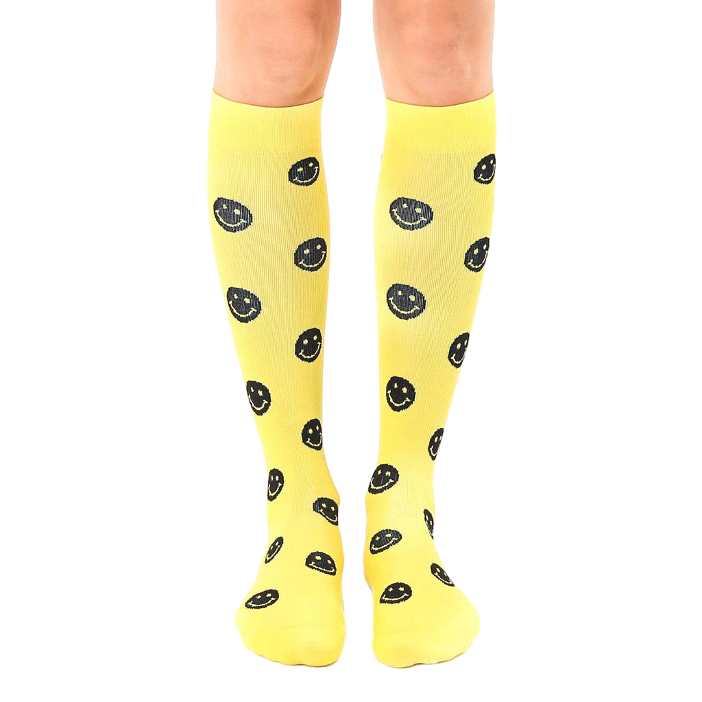 Pair of yellow knee-high socks with a repeating black smiley face pattern.  Fun and comfortable! [lf]
