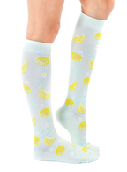 Lifestyle shot of a person wearing the lemon knee-high socks, showing the socks from the side. [lf]