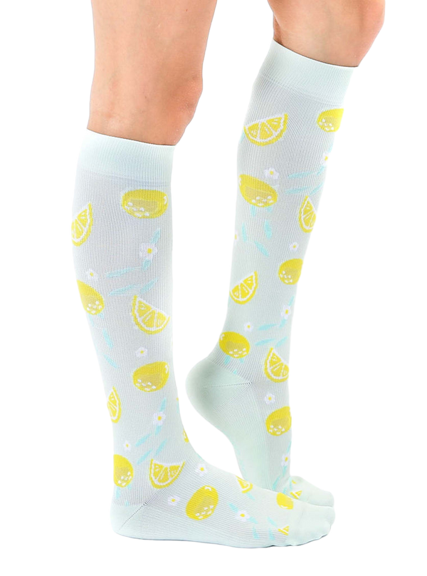 Lifestyle shot of a person wearing the lemon knee-high socks, showing the socks from the side. [lf]
