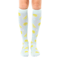 Pair of light blue knee-high socks with a lemon and flower pattern.  The lemons are yellow and the flowers are light teal. [lf]