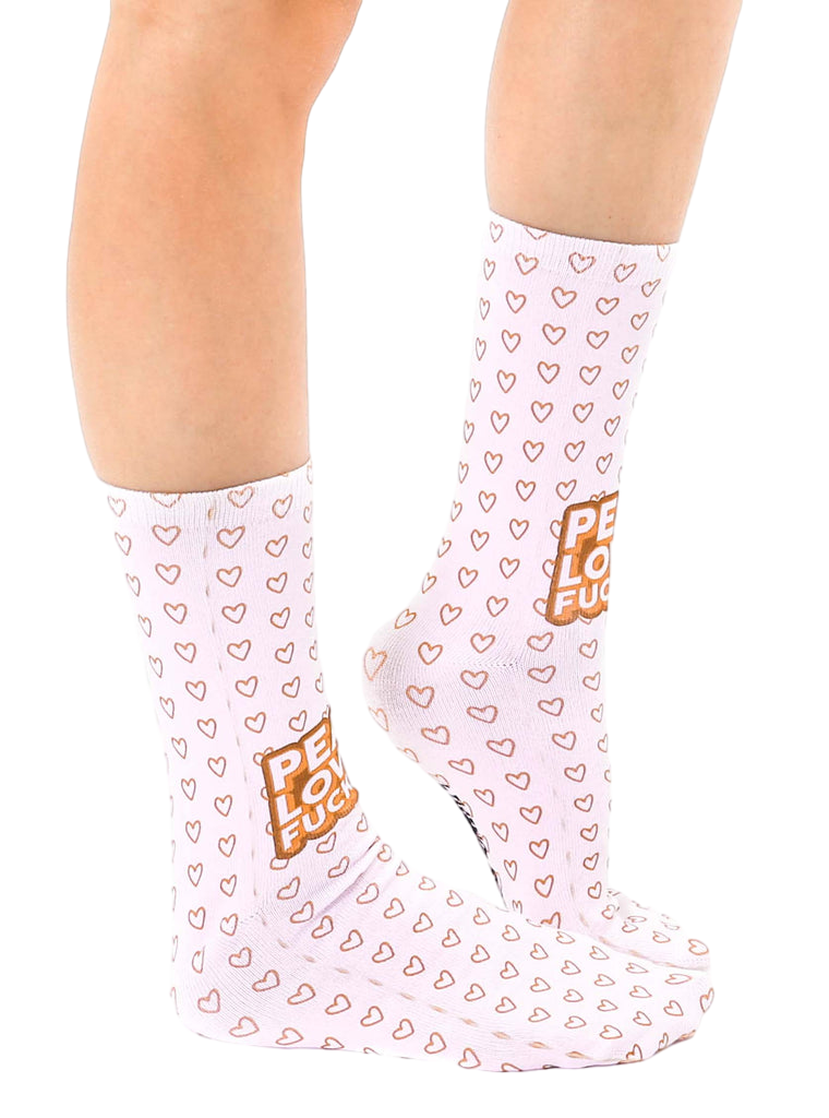 Lifestyle shot of a person's legs wearing the 'Peace Love' socks. Socks are shown from the side, highlighting their full length. [lf]