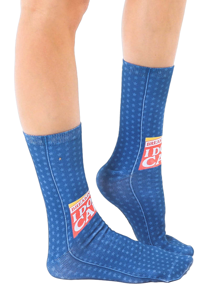 Lifestyle shot showing the 'Breaking News: I Don't Care' socks on a person's feet, showcasing the fit and design on a leg. [lf]