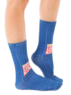 Lifestyle shot showing the 'Breaking News: I Don't Care' socks on a person's feet, showcasing the fit and design on a leg. [lf]