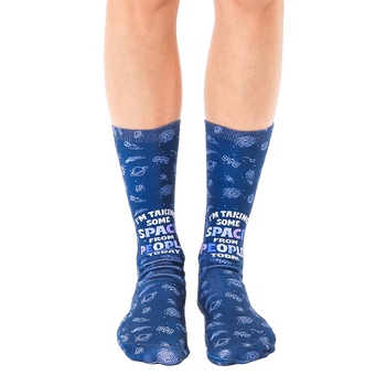 Pair of navy blue crew socks with a whimsical space-themed design, planets, shooting stars, and the text 'I'm taking some space from people today'. [lf]