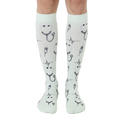 Pair of mint green knee-high socks with a pattern of stethoscopes, heartbeats, and syringes. [lf]