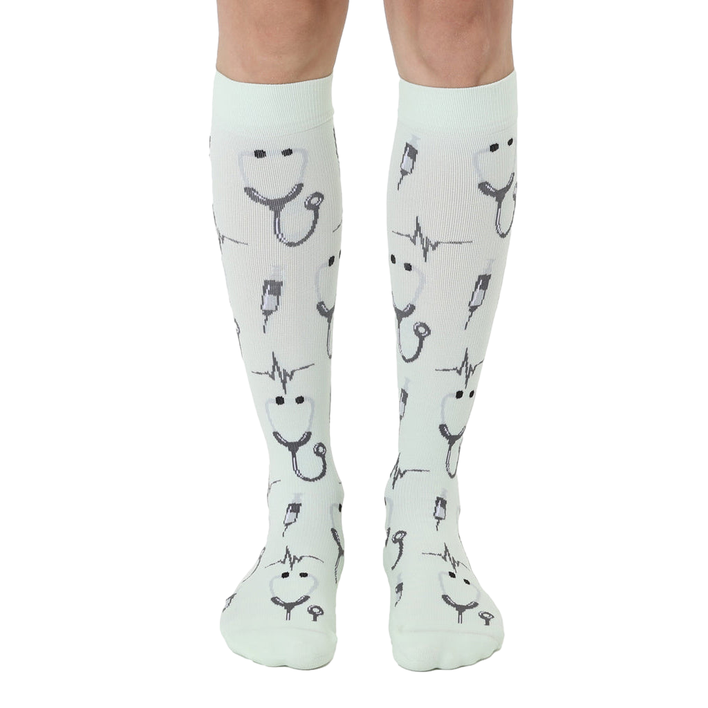 Pair of mint green knee-high socks with a pattern of stethoscopes, heartbeats, and syringes. [lf]