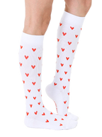 Lifestyle shot of a person's legs wearing the white knee-high socks with red hearts. [lf]