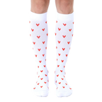 Pair of white knee-high socks with a repeating pattern of small red hearts. [lf]