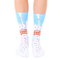A pair of white crew socks with a light blue milk splash design and colorful cereal pieces. The text 'Cereal Killer' is prominently displayed. [lf]