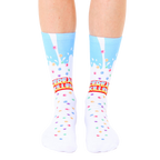 A pair of white crew socks with a light blue milk splash design and colorful cereal pieces. The text 'Cereal Killer' is prominently displayed. [lf]