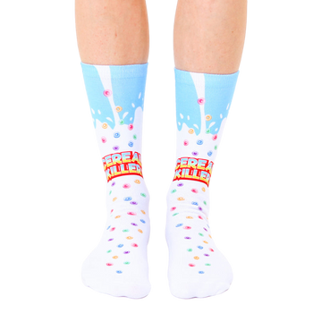 A pair of white crew socks with a light blue milk splash design and colorful cereal pieces. The text 'Cereal Killer' is prominently displayed. [lf]