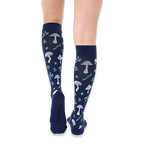 Back view of legs wearing navy blue knee-high socks showing the light blue mushroom and green leaf patterns on the calves.