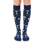 Front view of knee-high dark navy socks featuring a continuous pattern of light blue mushrooms and mint green woodland leaves.