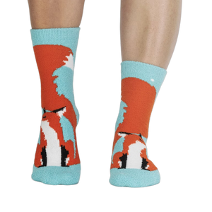 Pair of fox slipper socks on a person's legs. 