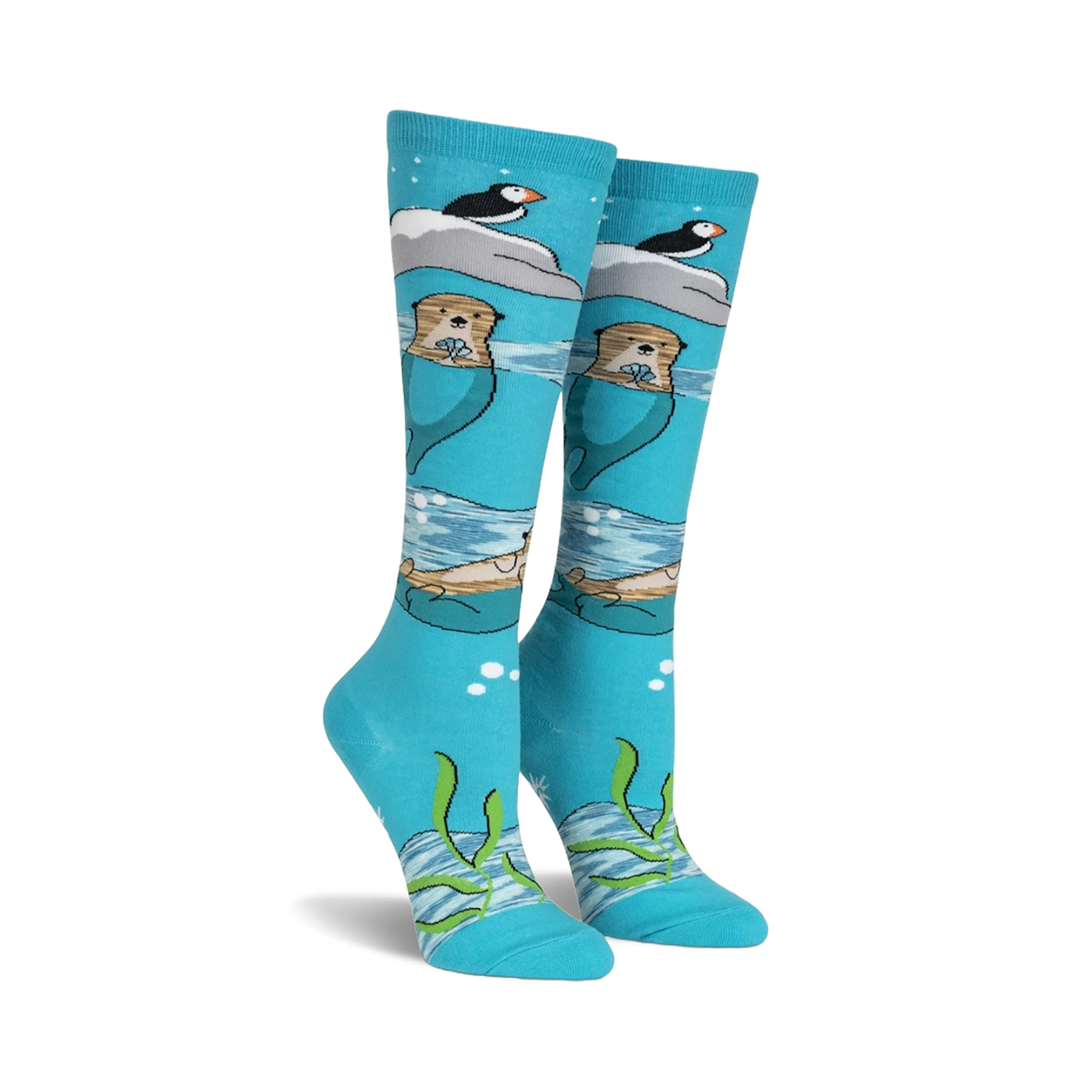 Pair of teal knee-high socks featuring otters, puffins, and icebergs.  Space dye yarn creates a whimsical, underwater scene.