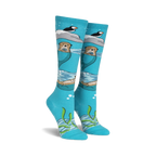Pair of teal knee-high socks featuring otters, puffins, and icebergs.  Space dye yarn creates a whimsical, underwater scene.