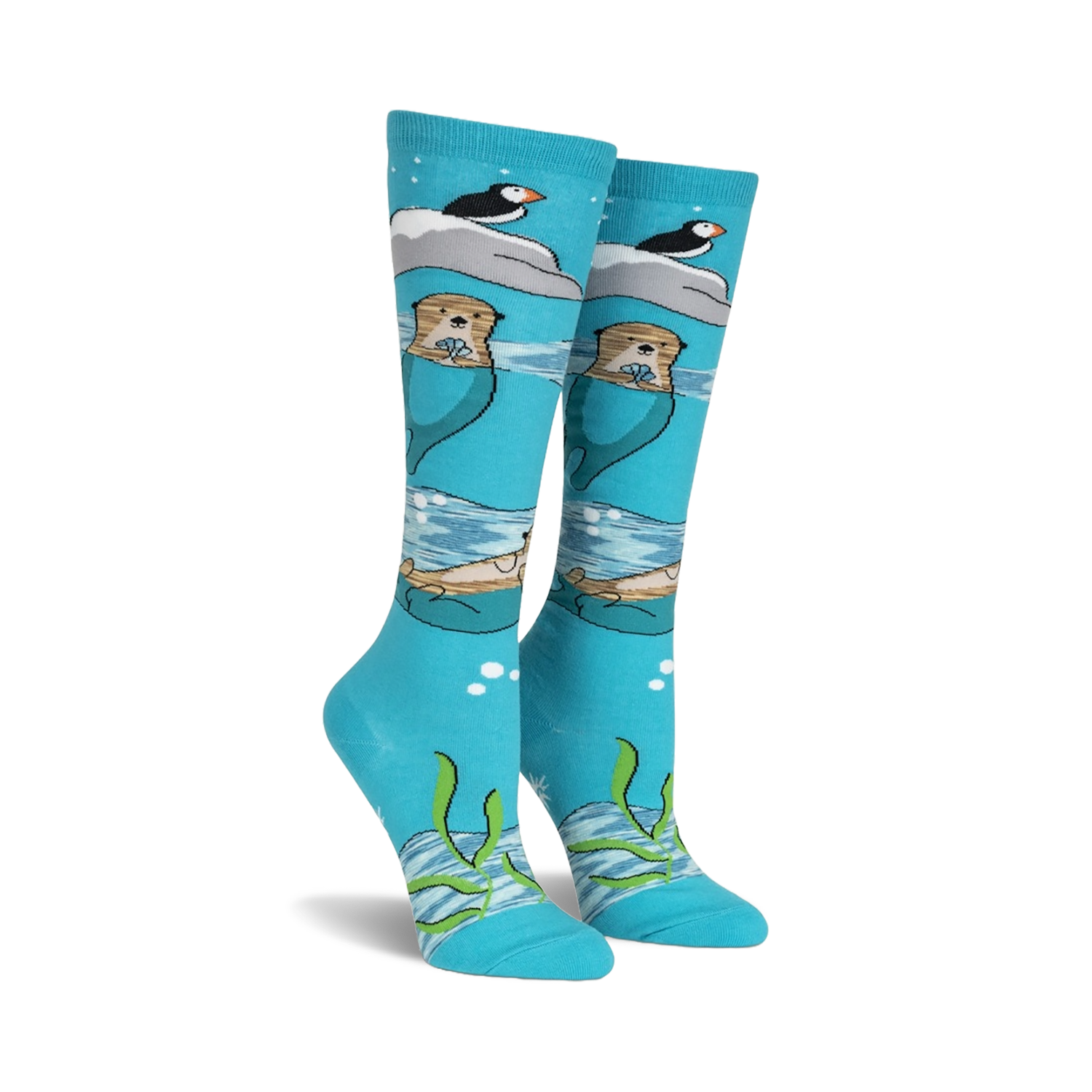 Pair of teal knee-high socks featuring otters, puffins, and icebergs.  Space dye yarn creates a whimsical, underwater scene.