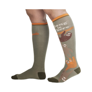 Lifestyle shot of a person wearing the 'Hang in There' sloth socks.