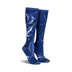Pair of knee-high socks in navy blue.  Features a whimsical design of narwhals and swirling ocean patterns with subtle shimmer.