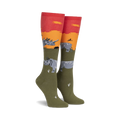 Pair of knee-high socks in olive green, orange, and red.  Design features rhinos against a sunset backdrop.