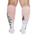 Back view of model wearing pink and white knee-high socks with a winter scene.