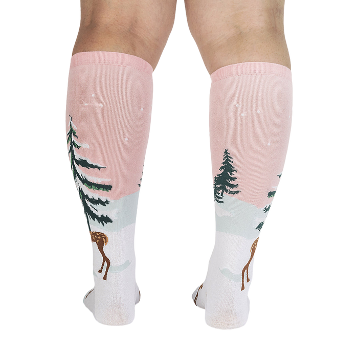 Back view of model wearing pink and white knee-high socks with a winter scene.