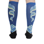 Rear view of the socks on a model's legs, highlighting the symmetrical design and glow-in-the-dark feature.