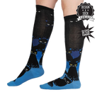 Lifestyle shot showing the socks on a person's legs, highlighting their length and glow-in-the-dark feature.