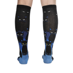 Rear view of the socks on a person's legs, showcasing the full design and cat pattern.