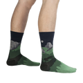 Lifestyle shot of a person wearing the Half Dome Yosemite socks, showcasing the socks' fit and design on the leg against a black background.