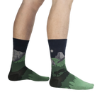 Lifestyle shot of a person wearing the Half Dome Yosemite socks, showcasing the socks' fit and design on the leg against a black background.