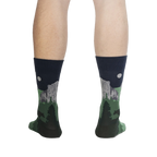 Rear view of the Half Dome Yosemite socks on a person's legs against a black background.  The socks' design is visible from the back.