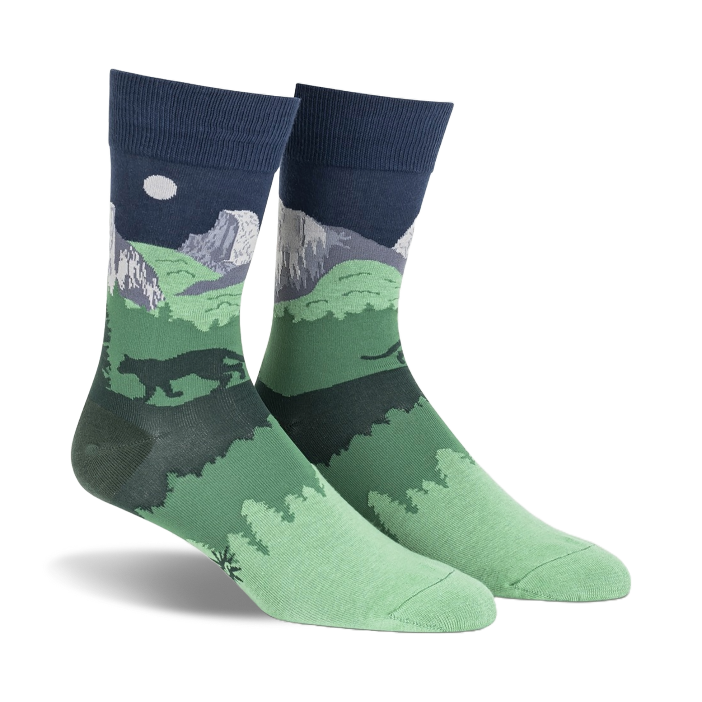 Pair of crew socks showcasing a nighttime scene of Half Dome in Yosemite National Park.  Dark green, navy blue, and gray colors depict mountains, trees, and a full moon.