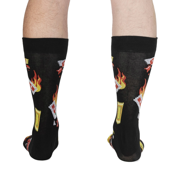 A pair of black socks with a pattern of hot sauce packets on fire.