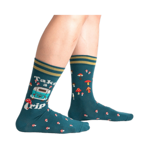 Lifestyle shot of a person wearing teal 'Take A Trip' socks, showcasing the socks on the feet.