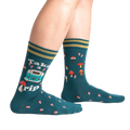 Lifestyle shot of a person wearing teal 'Take A Trip' socks, showcasing the socks on the feet.