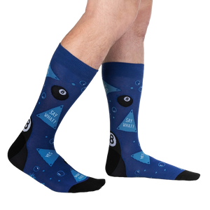 A pair of blue socks with a black heel and toe. The socks have a pattern of eight balls and triangles.