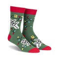 Crew socks in green with red cuffs, featuring a skeleton tangled in colorful Christmas lights.  The design glows in the dark!