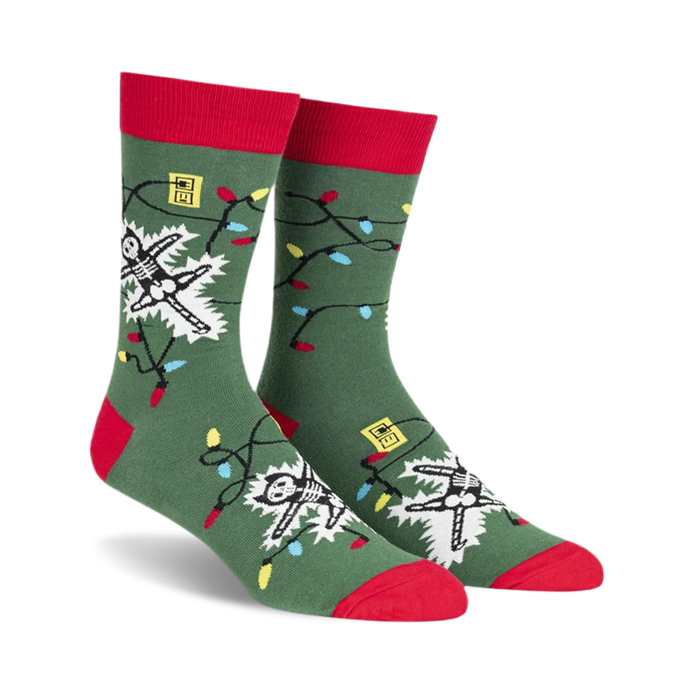 Crew socks in green with red cuffs, featuring a skeleton tangled in colorful Christmas lights.  The design glows in the dark!