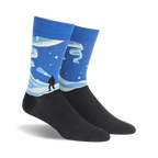 Crew socks showcasing a Northern Lights design. The socks are primarily blue with teal and white accents, depicting a snowy landscape and the aurora borealis.